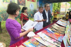 Khách tham quan đọc báo Xuân. (Nguồn: TTXVN)