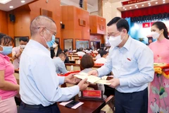 Chủ tịch Quốc hội Vương Đình Huệ tặng quà cán bộ, bác sỹ, người có công tại Thành phố Hồ Chí Minh. (Ảnh: Doãn Tấn/TTXVN)