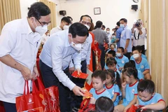 Chủ tịch Quốc hội Vương Đình Huệ tặng quà Tết cho trẻ khuyết tật. (Ảnh: Doãn Tấn/TTXVN)