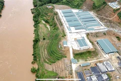 Những chiếc bể chứa chất thải chăn nuôi của trang trại lợn nằm lộ thiên ngay sát bờ sông Hồng. (Ảnh: Tuấn Anh/TTXVN)