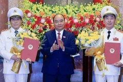 Chủ tịch nước Nguyễn Xuân Phúc trao Quyết định thăng cấp bậc hàm từ Trung tướng lên Thượng tướng đối với Thứ trưởng Bộ Công an Trần Quốc Tỏ và Lương Tam Quang. (Ảnh: Thống Nhất/TTXVN)