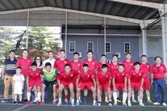 Đội Hội doanh nghiệp Việt Nam hợp tác và đầu tư tại Lào đang chụp ảnh lưu niệm trước khi bước vào thi đấu. (Ảnh: Phạm Kiên/TTXVN)