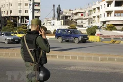 Lực lượng an ninh Chính phủ Syria gác tại một trạm kiểm soát ở Homs. (Nguồn: AFP/TTXVN)