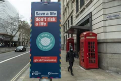Biển hiệu khuyến khích người dân đeo khẩu trang phòng dịch COVID-19 tại London, Anh. (Ảnh: THX/TTXVN)