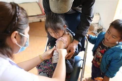 Nhân viên y tế tiêm vaccine phòng COVID-19 cho trẻ 5-12 tuổi tại xã Tà Tổng, Mường Tè, Lai Châu. (Ảnh: Nhật Anh/TTXVN)