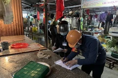 Lực lượng chức năng lập biên bản vi phạm hành chính. (Ảnh: Mạnh Tú/TTXVN)