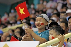 Cổ động viên nhí cổ vũ tại nhà thi đấu Hoàng Mai, Hà Nội. (Ảnh: Trần Việt/TTXVN)