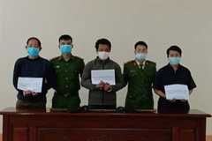 Các đối tượng cùng tang vật tại cơ quan điều tra Công an huyện Mèo Vạc, tỉnh Hà Giang. (Ảnh: TTXVN phát)