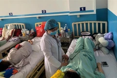 Kiểm tra tình trạng sức khỏe cho một thai phụ mắc sốt xuất huyết. (Ảnh: Đinh Hằng/TTXVN)