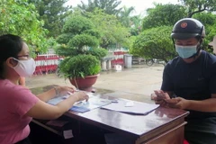 Chi trả tiền hỗ trợ người dân bị ảnh hưởng bởi dịch COVID-19. (Nguồn: TTXVN)