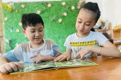Hai chị em Lê Ngọc Thiên Ân (bên phải) và Lê Ngọc Bảo (bên trái) đam mê ngoại ngữ khi còn nhỏ. (Ảnh: TXVN phát)