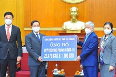 Chủ tịch Mặt trận Tổ quốc Việt Nam Đỗ Văn Chiến tiếp nhận tượng trưng số tiền ủng hộ phòng, chống dịch của cộng đồng người Việt tại Canada. (Ảnh: Minh Đức/TTXVN)