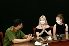 Hai nữ du khách người Nga nhận lại tài sản tại cơ quan công an. (Ảnh: TTXVN phát)