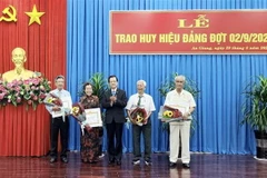 Ông Lê Hồng Quang, Bí thư Tỉnh ủy An Giang, trao huy hiệu 60 năm tuổi Đảng cho 4 đảng viên. (Ảnh: Thanh Sang/TTXVN)