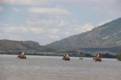 Du khách cưỡi voi dạo Hồ Lắk. (Ảnh: Nguyễn Tuấn Anh/TTXVN)