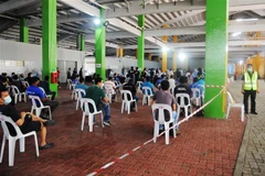 Công nhân xếp hàng chờ xét nghiệm COVID-19 tại Singapore ngày 10/6/2020. (Ảnh: THX/ TTXVN)
