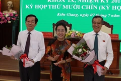 Tặng hoa chúc mừng tân Chủ tịch Đỗ Thanh Bình (trái) và nguyên Chủ tịch UBND tỉnh Phạm Vũ Hồng. (Ảnh: Lê Sen/TTXVN)