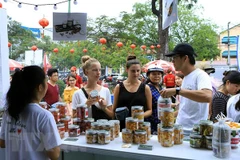 Du khách nước ngoài tham quan mua sắm tại Liên hoan ẩm thực quốc tế tại Festival Huế 2018. (Ảnh: Hoàng Hùng/TTXVN)