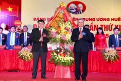 Ủy viên Trung ương Đảng,Bí thư Tỉnh ủy Thừa Thiên-Huế Lê Trường Lưu (phải) tặng hoa chúc mừng Đại hội. (Ảnh: Mai Trang/TTXVN)