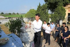 Đoàn đại biểu Thông tấn xã Việt Nam do Tổng Giám đốc Nguyễn Đức Lợi dẫn đầu đến đặt vòng hoa và dâng hương viếng các liệt sỹ tại nghĩa trang liệt sỹ thị trấn Chúc Sơn. (Ảnh: Dương Giang/TTXVN)