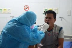 Nhân viên y tế bệnh viện 199 lấy mẫu xét nghiệm, thực hiện sàng lọc khi tiếp nhận bệnh nhân. (Ảnh: Văn Dũng/TTXVN)