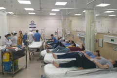 Các công nhân mắc các triệu chứng nghi ngộ độc thực phẩm đang được điều trị tích cực tại Bệnh viện đa khoa Đồng Nai. (Ảnh: Lê Xuân/TTXVN)