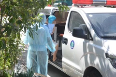 Đưa trường hợp tiếp xúc gần với bệnh nhân nghi nhiễm COVID-19 đi cách ly tại Trung tâm Y tế quận Liên Chiểu. (Ảnh: Văn Dũng/TTXVN)