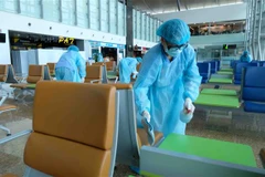 Vệ sinh, khử trùng khu vực nhà ga đến tại Sân bay quốc tế Cam Ranh sau mỗi đợt đón khách quốc tế. (Ảnh: Nguyễn Dũng/TTXVN)