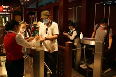 Du khách thực hiện sát khuẩn tay khi vào cửa soát vé để thăm quan Khu du lịch Bà Nà Hills. (Ảnh: Trần Lê Lâm/TTXVN)