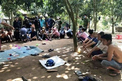 Các đối tượng đánh bạc dưới hình thức lắc tài xỉu bị lực lượng chức năng bắt quả tang. (Ảnh: TTXVN phát)