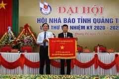 Chủ tịch UBND tỉnh Quảng Trị Võ Văn Hưng trao tặng Cờ thi đua đơn vị dẫn đầu phong trào thi đua năm 2019 cho Hội Nhà báo tỉnh. (Ảnh: Hồ Cầu-TTXVN)