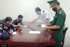 Lực lượng chức năng làm việc với Ngô Văn Hồng và Phan Thị Anh. (Ảnh: TTXVN phát)