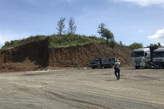 Khu đồi đất bị san ủi gần hết để lập bến bãi đỗ xe tải. (Ảnh: Phạm Cường/TTXVN)