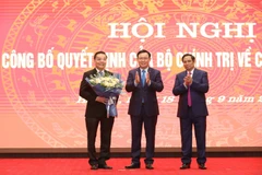 Trưởng ban Tổ chức Trung ương Phạm Minh Chính và Bí thư Thành ủy Hà Nội Vương Đình Huệ chúc mừng đồng chí Chu Ngọc Anh. (Ảnh: Văn Điệp/TTXVN)