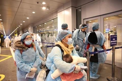 Công dân Việt Nam làm thủ tục tại sân bay Vân Đồn dưới sự giám sát chặt chẽ của lực lượng chức năng. (Ảnh: Dương Giang/TTXVN)