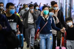 Hành khách đeo khẩu trang đề phòng lây nhiễm virus 2019-nCoV tại một nhà ga ở Hong Kong, Trung Quốc. (Ảnh: AFP/TTXVN)