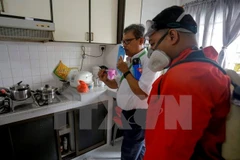 Nhân viên Công ty NEA hướng dẫn người dân diệt muỗi trong nhà ở quận Bedok North ngày 1/9. (Nguồn: EPA/ TTXVN)