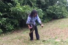 Cô gái bình tĩnh bắt con rắn. (Nguồn: LiveLake)