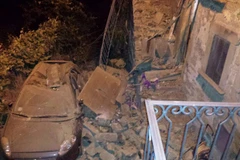 Một chiếc xe hơi bị bẹp nóc vì gạch rơi sau vụ động đất. (Nguồn: Yahoo News)