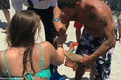 Các du khách và nhân viên cứu hộ cố gắng giúp đỡ cô gái. (Nguồn: Daily Mail)