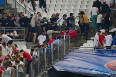 Cổ động viên Nga và Anh lao qua phần rào chắn để đánh nhau. (Nguồn: Getty)