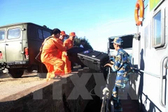 Lực lực lượng tìm kiếm cứu nạn ngành hàng không di chuyển lên tàu HQ211. (Ảnh: Thanh Tùng/TTXVN)