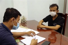 Lấy lời khai của đối tượng đánh bạc đã bị bắt giữ. (Ảnh: Công Thử/TTXVN)