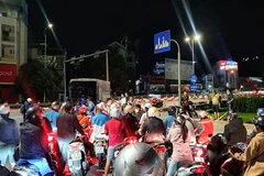 Dòng người đi xe máy chờ được chở qua cầu Bãi Cháy lúc 20 giờ 30 phút, ngày 13/10. (Ảnh: TTXVN)