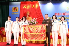 Đại tướng Tô Lâm - Ủy viên Bộ Chính trị, Bộ trưởng Bộ Công an trao tặng bức trướng của Đảng ủy Công an Trung ương cho Hội Phụ nữ Bộ Công an. (Ảnh: Phạm Kiên/TTXVN)
