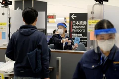 Nhân viên hướng dẫn hành khách tại khu vực kiểm dịch của sân bay Narita (Nhật Bản). (Ảnh: AFP/TTXVN)