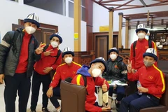 Các cầu thủ U23 Việt Nam thích thú với chiếc mũ kalpak truyền thống của Kyrgyzstan. (Ảnh: TTXVN)