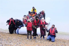 Người di cư từ Pháp được đưa về bãi biển ở Dungeness (Anh), sau khi được giải cứu ở eo biển Manche ngày 24/11/2021. (Ảnh: THX/TTXVN)