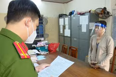 Nguyễn Thị Kim Hạnh (tức Mười Tường) nghe công an đọc quyết định khởi tố. (Ảnh: TTXVN)