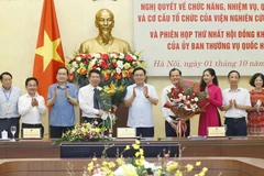 Chủ tịch Quốc hội Vương Đình Huệ trao nghị quyết và tặng hoa chúc mừng lãnh đạo Viện Nghiên cứu lập pháp. (Ảnh: Doãn Tấn/TTXVN)